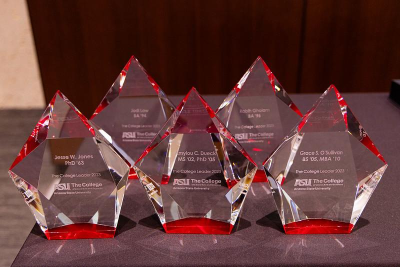 Five diamond-shaped acrylic trophies lined up on a table.