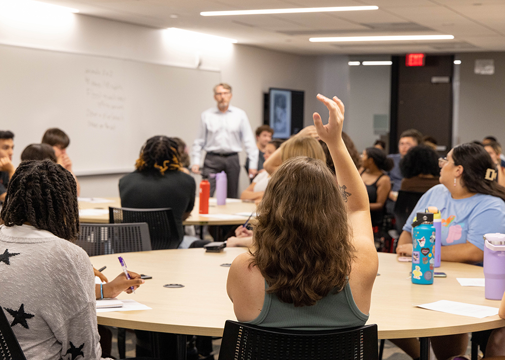 An ASU Early Start participant raises her hand in Dean of Humanities Jeffrey Cohen's class.